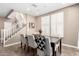 Dining room with stylish table, chairs, and modern decor next to a staircase and plantation shutters at 36145 N Desert Tea Dr, Queen Creek, AZ 85140