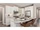 Bright kitchen boasts white cabinets, granite countertops, stainless steel appliances, and a stylish island with seating at 36145 N Desert Tea Dr, Queen Creek, AZ 85140