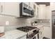 Well-equipped kitchen featuring stainless steel appliances, granite countertops, and classic white cabinetry for ample storage at 36145 N Desert Tea Dr, Queen Creek, AZ 85140