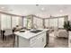 Spacious kitchen island with seating, adjacent to a dining area and living room with large windows and natural light at 36145 N Desert Tea Dr, Queen Creek, AZ 85140