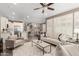 Open-concept living room with comfortable seating, adjacent to the kitchen and dining area at 36145 N Desert Tea Dr, Queen Creek, AZ 85140