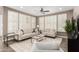 Well-lit living room featuring stylish furniture, plantation shutters, and a neutral color palette at 36145 N Desert Tea Dr, Queen Creek, AZ 85140