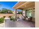 Charming covered patio with brick pavers, seating area, and views of the beautifully landscaped backyard at 36145 N Desert Tea Dr, Queen Creek, AZ 85140