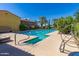 Outdoor lap pool with clear blue water, surrounded by lush landscaping, perfect for exercise and relaxation at 36145 N Desert Tea Dr, Queen Creek, AZ 85140