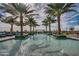 Resort-style pool with lounge chairs and palm trees offers a relaxing outdoor oasis for residents and guests at 36145 N Desert Tea Dr, Queen Creek, AZ 85140