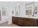 Bright bathroom features a brown double vanity, neutral countertop, modern faucets, and large mirrors at 4077 S Sabrina Dr # 48, Chandler, AZ 85248
