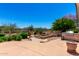 Backyard retreat featuring a cozy fire pit, barbecue, lush landscaping, and mature trees at 4633 E Chaparosa Way, Cave Creek, AZ 85331