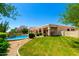 Lush backyard featuring a pool, grassy area, mature trees, and covered patio at 4633 E Chaparosa Way, Cave Creek, AZ 85331