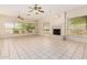 Large living room with a fireplace, tile floors, and multiple windows at 4633 E Chaparosa Way, Cave Creek, AZ 85331