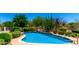 Sparkling pool with a rock waterfall feature surrounded by lush desert landscaping at 4633 E Chaparosa Way, Cave Creek, AZ 85331