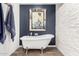 Elegant bathroom featuring a freestanding tub with claw feet and unique stone accent wall at 4833 N 38Th St, Phoenix, AZ 85018