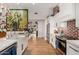 Bright kitchen features a white farmhouse sink, stainless steel appliances, and an island with white countertops at 4833 N 38Th St, Phoenix, AZ 85018