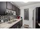 Kitchen with black cabinets, stainless steel sink, and decorative backsplash at 4833 N 38Th St, Phoenix, AZ 85018