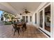Covered patio with tile flooring featuring a large wood dining table and ceiling fan for outdoor comfort at 4833 N 38Th St, Phoenix, AZ 85018