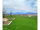 Well-manicured community green space with lush grass and mountain views in the background at 4936 S 106Th Ln, Tolleson, AZ 85353