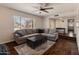 Bright living room featuring a large window, hardwood floors, and a comfortable gray sectional sofa at 4944 W Vista Ave, Glendale, AZ 85301