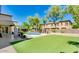 Sprawling backyard featuring manicured lawn, pool with water feature, and covered patio at 614 E Benrich Dr, Gilbert, AZ 85295