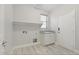 Well-lit laundry room featuring a sink, granite countertop, shelf, and ample space for appliances at 614 E Benrich Dr, Gilbert, AZ 85295