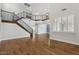 Spacious living room features hardwood floors, staircase with iron railing, and large windows with shutter blinds at 614 E Benrich Dr, Gilbert, AZ 85295