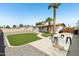 Expansive backyard with artificial turf, a fire pit, and mature palm trees for added appeal at 653 W Inglewood St, Mesa, AZ 85201