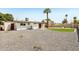 Large backyard with gravel, artificial turf, mature trees, and a covered patio area at 653 W Inglewood St, Mesa, AZ 85201
