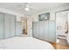 Bedroom showcasing a television, access to the bathroom with subway tile shower, and wood floors at 653 W Inglewood St, Mesa, AZ 85201