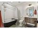 Vintage-style bathroom featuring a clawfoot tub and rustic vanity with modern fixtures at 653 W Inglewood St, Mesa, AZ 85201