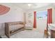 Bright Bedroom with a crib, cozy chair, and charming decor, perfect for a young  at 653 W Inglewood St, Mesa, AZ 85201