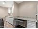 Organized laundry room with granite countertops, white cabinetry, and built-in pet crate at 6810 E Almeria Rd, Scottsdale, AZ 85257
