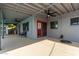 Covered patio with dual ceiling fans, painted concrete, bench, and a red-framed sliding door at 6810 E Almeria Rd, Scottsdale, AZ 85257