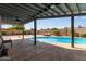 Covered patio overlooking a sparkling pool, lounge chairs, manicured plants and fence at 6810 E Almeria Rd, Scottsdale, AZ 85257