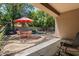 Covered patio and backyard with a table and chairs, garden, and a refreshing pool at 8237 W Alex Ave, Peoria, AZ 85382