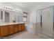 Bright bathroom with double sink vanity, tile flooring, and walk-in shower with glass door at 8237 W Alex Ave, Peoria, AZ 85382