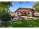 A view of the home's exterior from the backyard, showcasing a covered patio and well-maintained landscaping at 8237 W Alex Ave, Peoria, AZ 85382