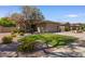 Well-maintained single-story home with lush landscaping, green lawn, and a two-car garage on a sunny day at 8237 W Alex Ave, Peoria, AZ 85382
