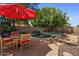 Inviting pool area with a rock-lined pool, patio space, and a charming outdoor dining set under a red umbrella at 8237 W Alex Ave, Peoria, AZ 85382