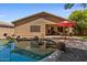 Backyard view showcases the glistening pool, covered patio, and the home's exterior with its inviting outdoor spaces at 8237 W Alex Ave, Peoria, AZ 85382