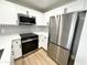 Updated kitchen with stainless steel appliances, modern white cabinets and tiled backsplash at 8625 E Belleview Pl # 1070, Scottsdale, AZ 85257