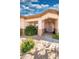 Charming single-story home featuring a well-manicured front yard with colorful foliage, rocks, and tasteful desert landscaping at 8765 W Custer Ln, Peoria, AZ 85381