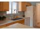 Functional kitchen features stainless steel sink, oak-finish cabinetry, laminate countertops, and lots of counter space at 8765 W Custer Ln, Peoria, AZ 85381