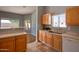 Well-lit kitchen featuring wood cabinetry, stainless steel sink, and tile flooring at 8765 W Custer Ln, Peoria, AZ 85381