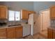 Functional kitchen with a stainless steel sink, a white refrigerator, and oak-finish cabinetry at 8765 W Custer Ln, Peoria, AZ 85381