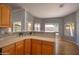 Sunlit kitchen featuring wood cabinets, laminate countertops, and pass-through counters with views of the exterior at 8765 W Custer Ln, Peoria, AZ 85381