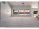 Expansive living room with neutral carpet, three rear picture windows, and light gray wall paint at 8765 W Custer Ln, Peoria, AZ 85381