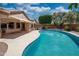 Inviting backyard pool with a covered patio, landscaped yard, and sunny skies at 8765 W Custer Ln, Peoria, AZ 85381
