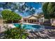 An in-ground pool is surrounded by desert landscaping in the backyard at 8765 W Custer Ln, Peoria, AZ 85381