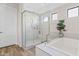 Luxurious bathroom showcasing a glass-enclosed shower, soaking tub and sleek fixtures at 10520 E Thorite Cir, Mesa, AZ 85212