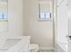 Bathroom showcasing a bathtub with tile surround, a window, and a modern sink and toilet at 10520 E Thorite Cir, Mesa, AZ 85212