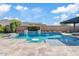 Beautiful outdoor pool featuring travertine deck, built-in water features, and lush landscaping at 10520 E Thorite Cir, Mesa, AZ 85212