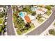 An elevated view of a neighborhood, showcasing a home with a red tile roof, beautiful pool, and desert landscaping at 10658 E Cinnabar Ave, Scottsdale, AZ 85258